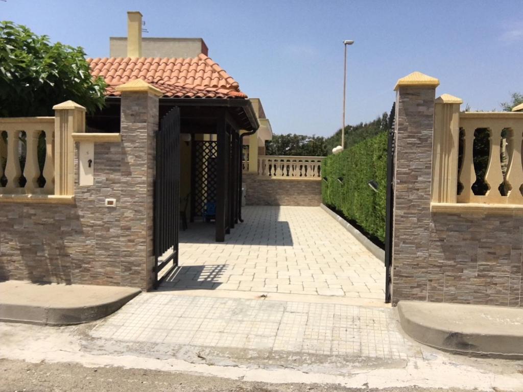 un cancello per una casa con una recinzione di Punta Prosciutto apartments to rent a Punta Prosciutto