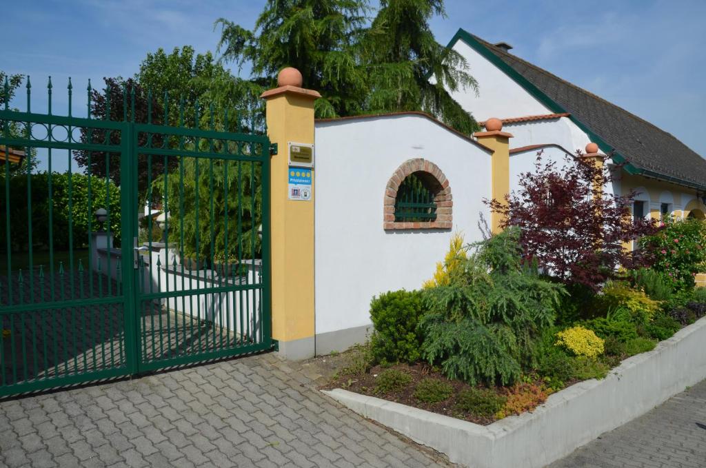 a gate in front of a small white house at Ferienwohnung Herrmann Pottenhofen in Pottenhofen
