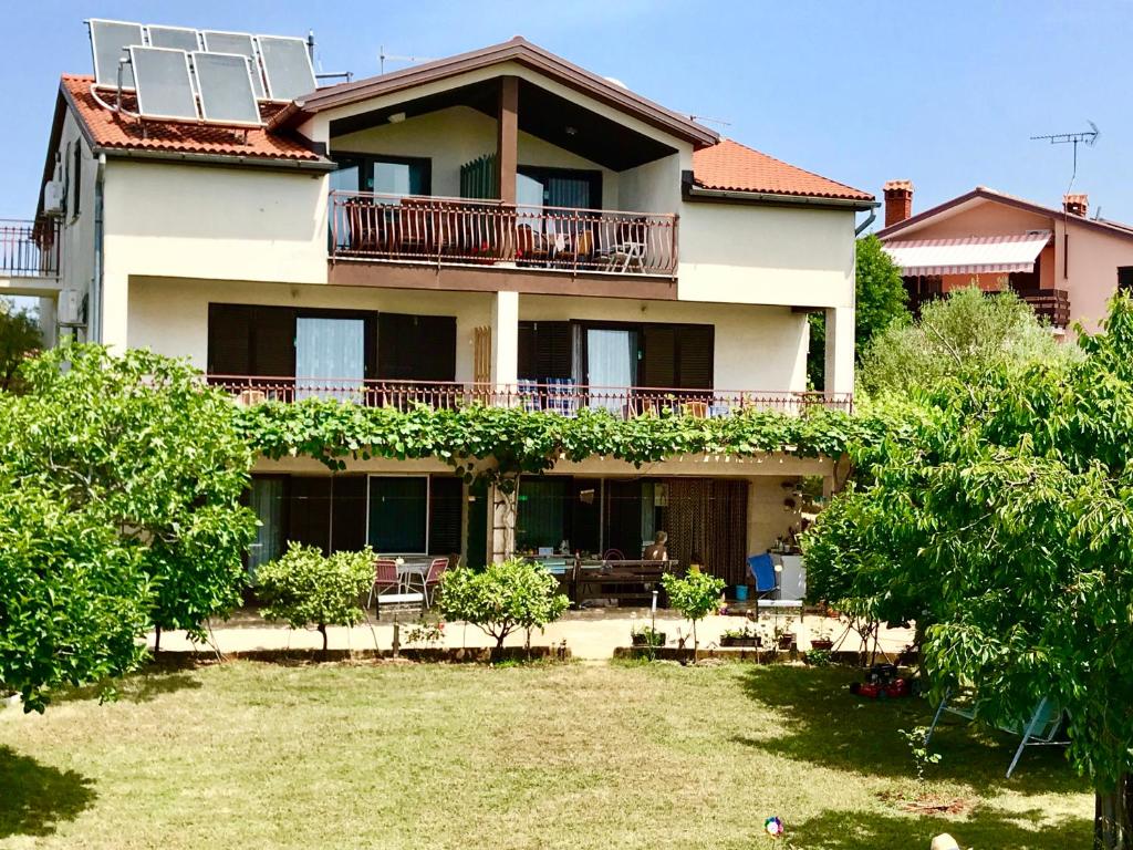 ein großes Haus mit einem Hof davor in der Unterkunft Apartments Markelj in Lovrečica