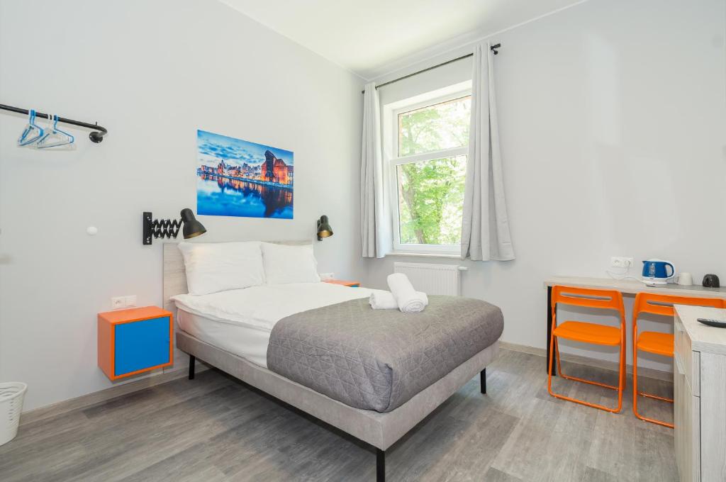 małą sypialnię z łóżkiem i kuchnią w obiekcie Zefiro Stajenna w Gdańsku