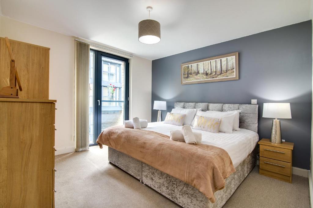 een slaapkamer met een groot bed en een groot raam bij Arcadian City Centre Apartment in Birmingham