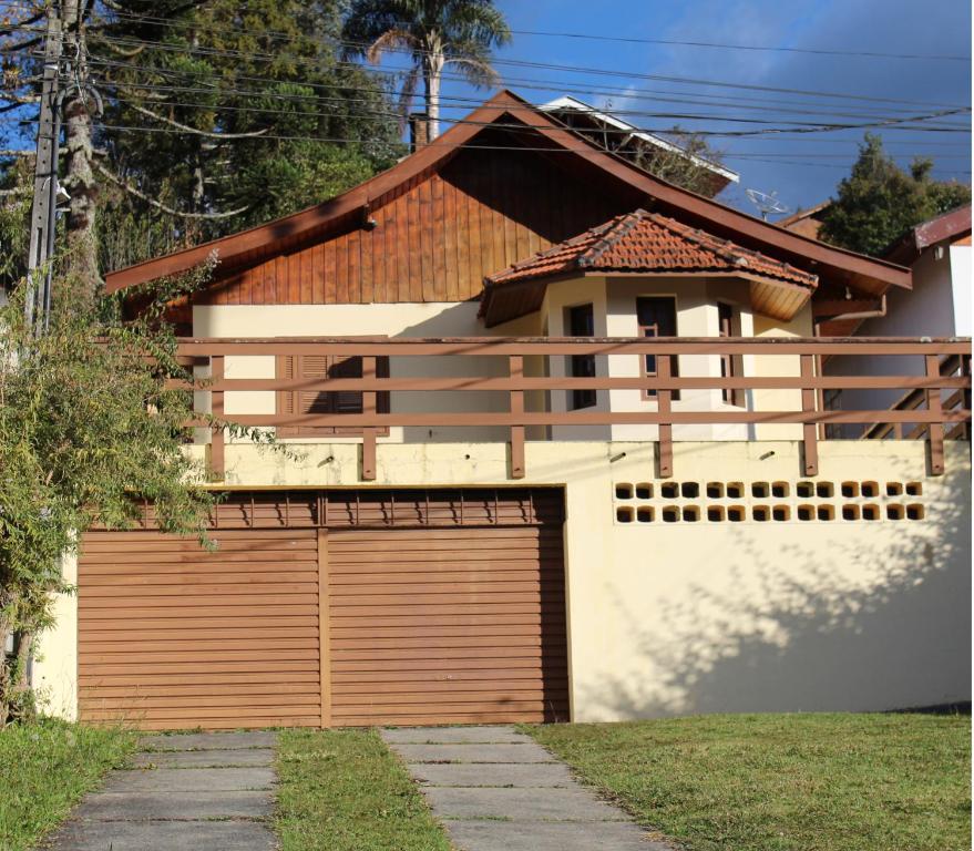 a house with a garage door in front of it at Casa de Lazer em Campos do Jordao in Campos do Jordão