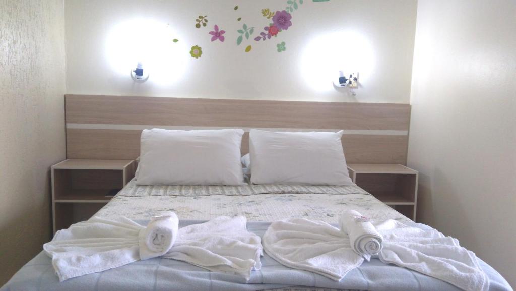 um quarto com uma cama com toalhas em Hotel Itamiaru em Iguape