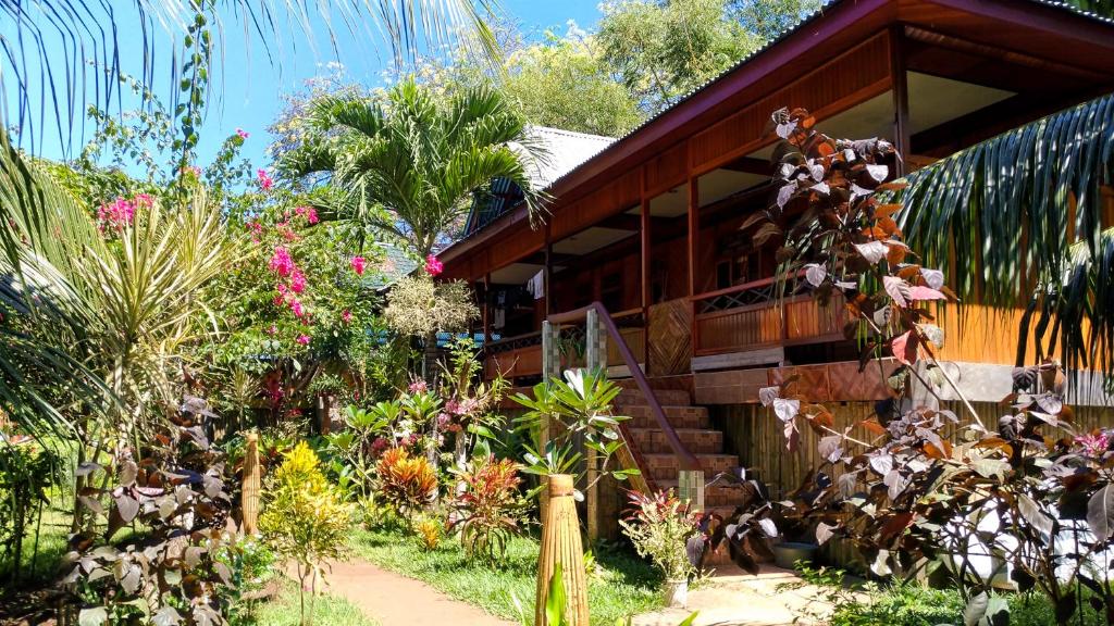 a house with a bunch of plants in front of it at Panorama Backpackers in Bunaken