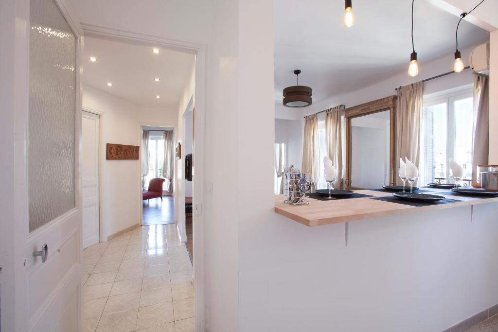 eine weiße Küche mit einer Theke und einem Spiegel in der Unterkunft Place au Manege in Marseille