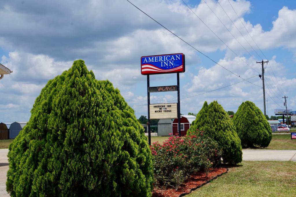 una señal para una posada americana frente a los árboles en American Inn of Kinder, en Kinder