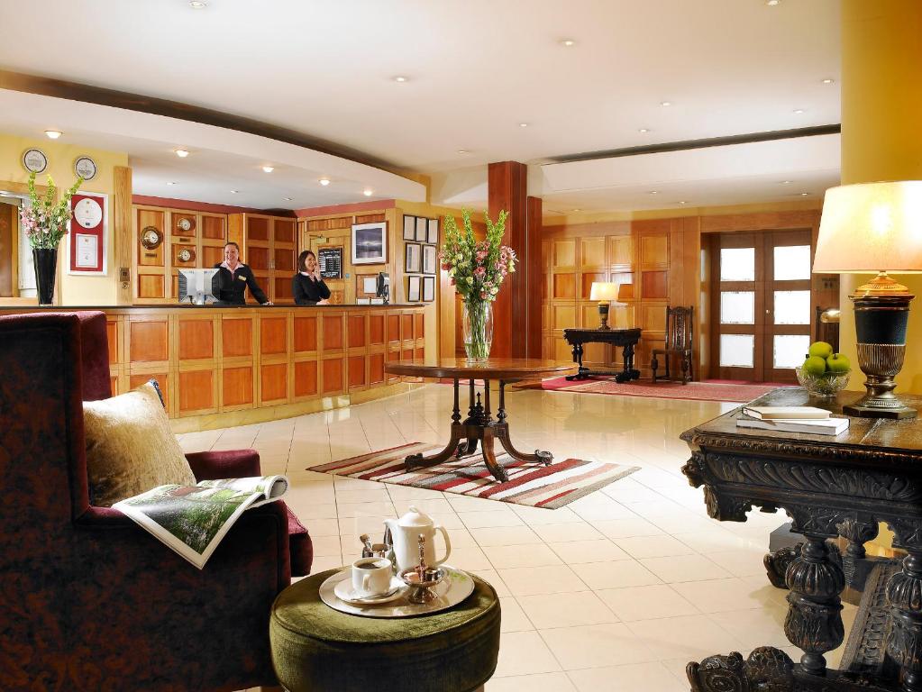 a lobby with a piano and two people in a room at Hotel Westport - Leisure Spa and Conference in Westport