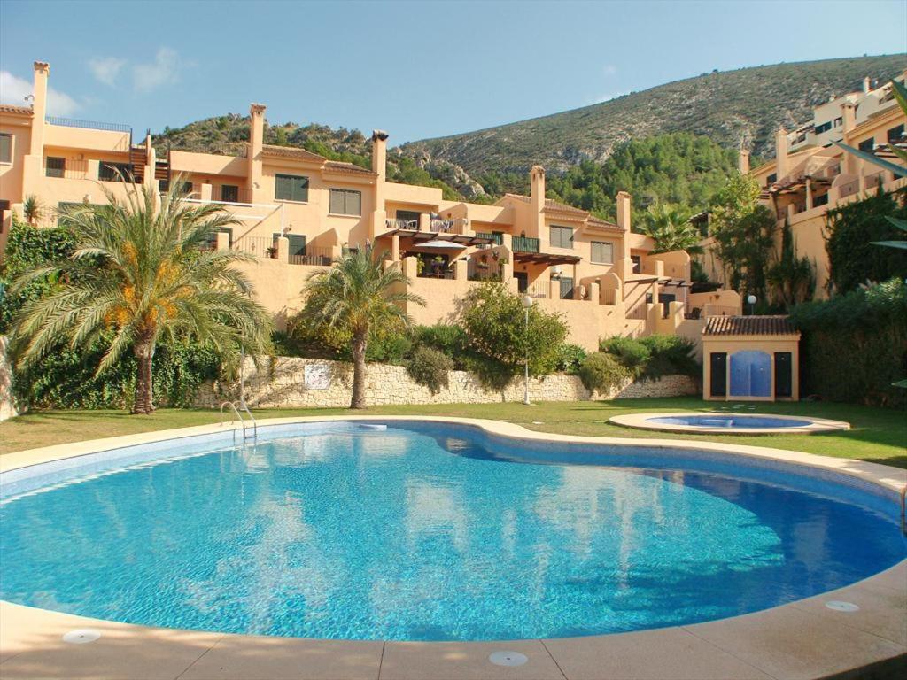 Una gran piscina azul frente a un edificio en Bungalow La Joya, en Benitachell