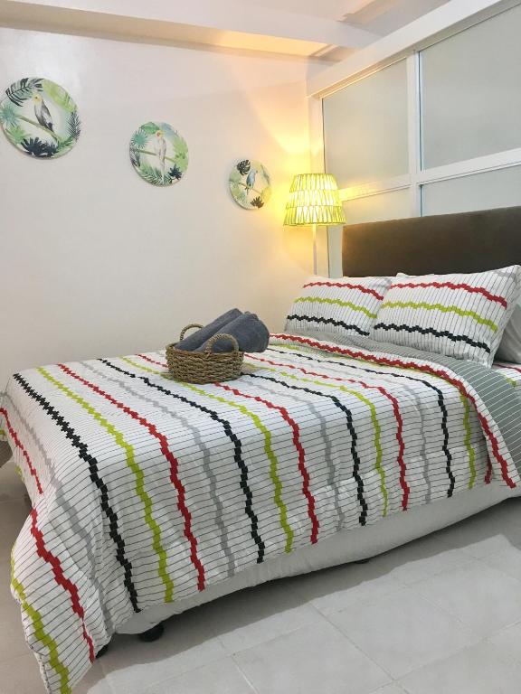 a bedroom with a bed with a colorful striped blanket at Sofia's Tagaytay Getaway in Tagaytay