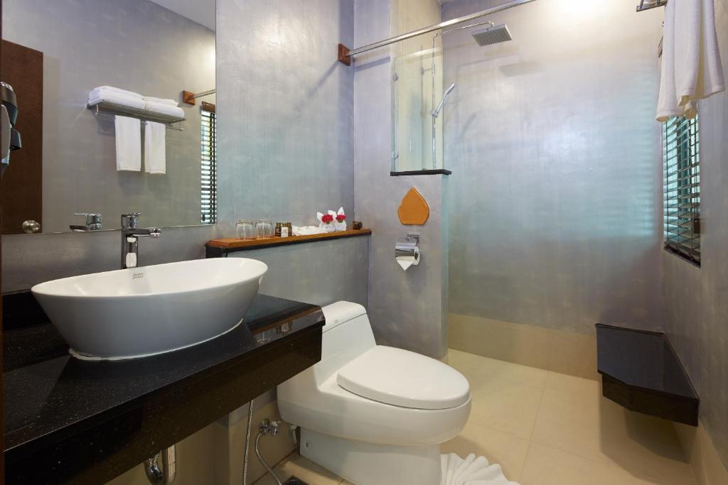 a bathroom with a white toilet and a sink at The Agate Pattaya Boutique Resort in Pattaya South