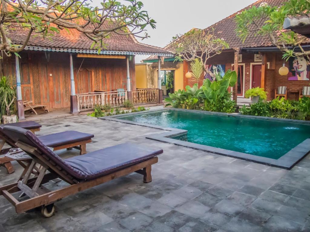 a villa with a swimming pool in front of a house at Griya Pasir Ukir in Sanur