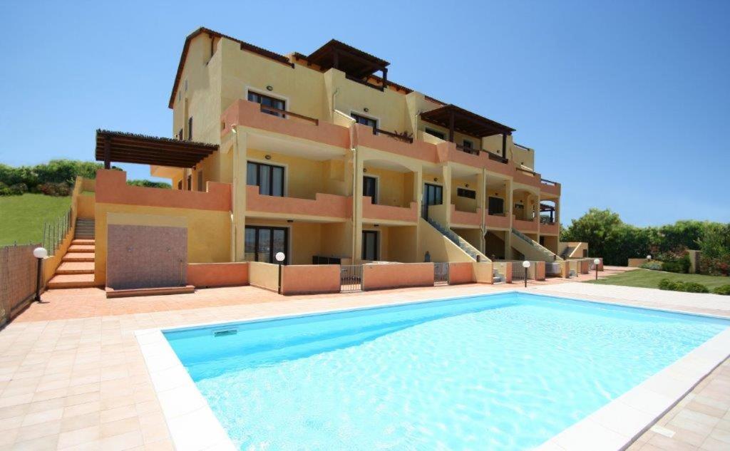 eine Villa mit einem Pool vor einem Haus in der Unterkunft happy sun apartment in Castelsardo