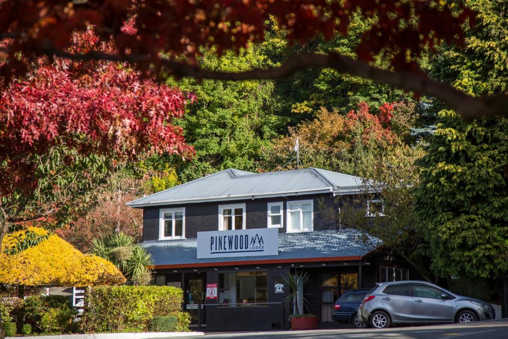 a building with a car parked in front of it at Pinewood Lodge and Apartments in Queenstown