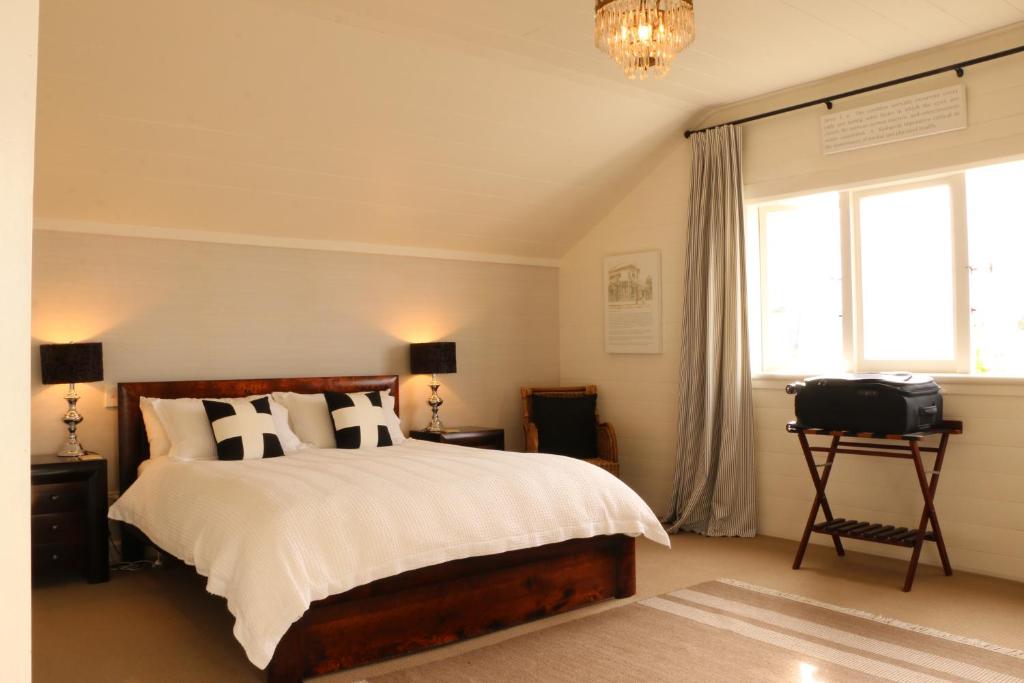 a bedroom with a bed and a window and a television at Historic Colenso Cottage in Napier