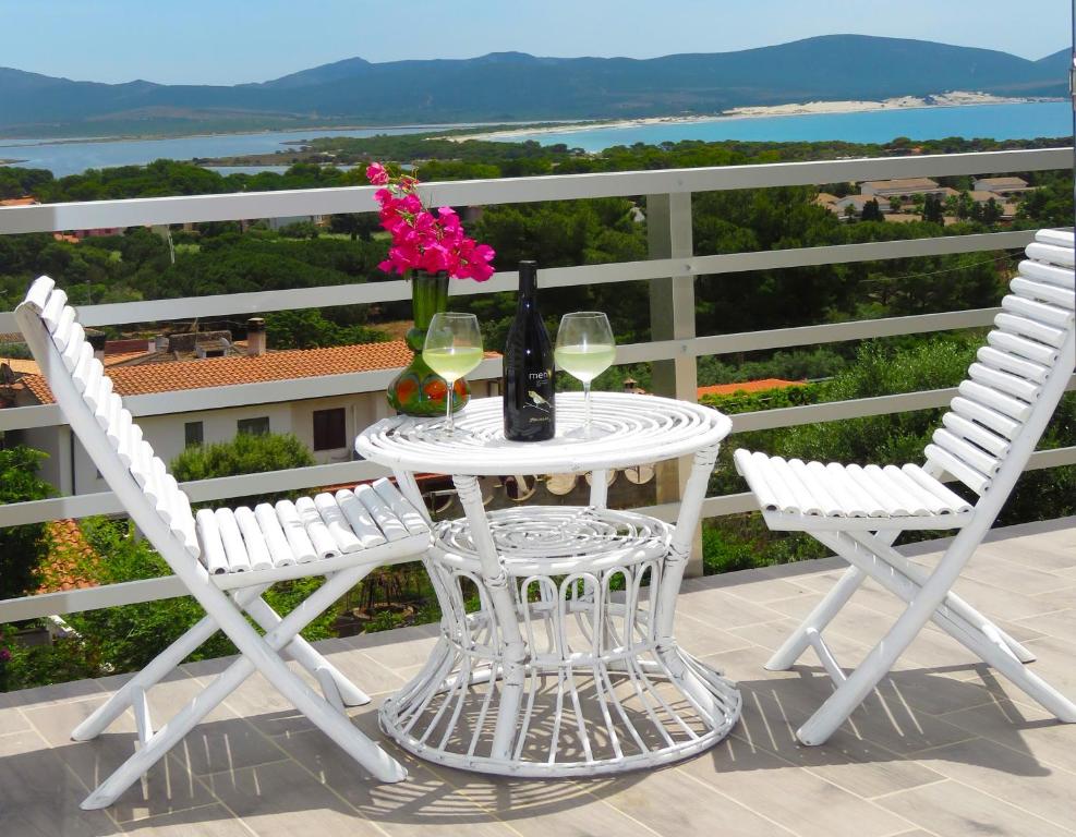 uma mesa branca com duas cadeiras e uma garrafa de vinho em Panohome em Porto Pino