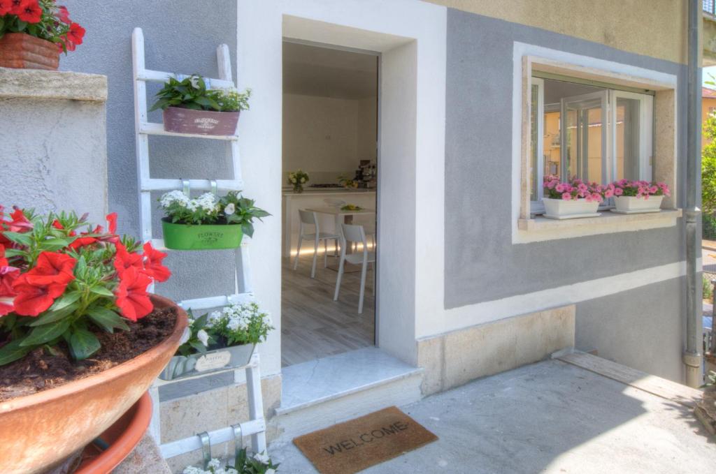 a room with a window and a garden with flowers in it at Rione San Carlo in Finale Ligure