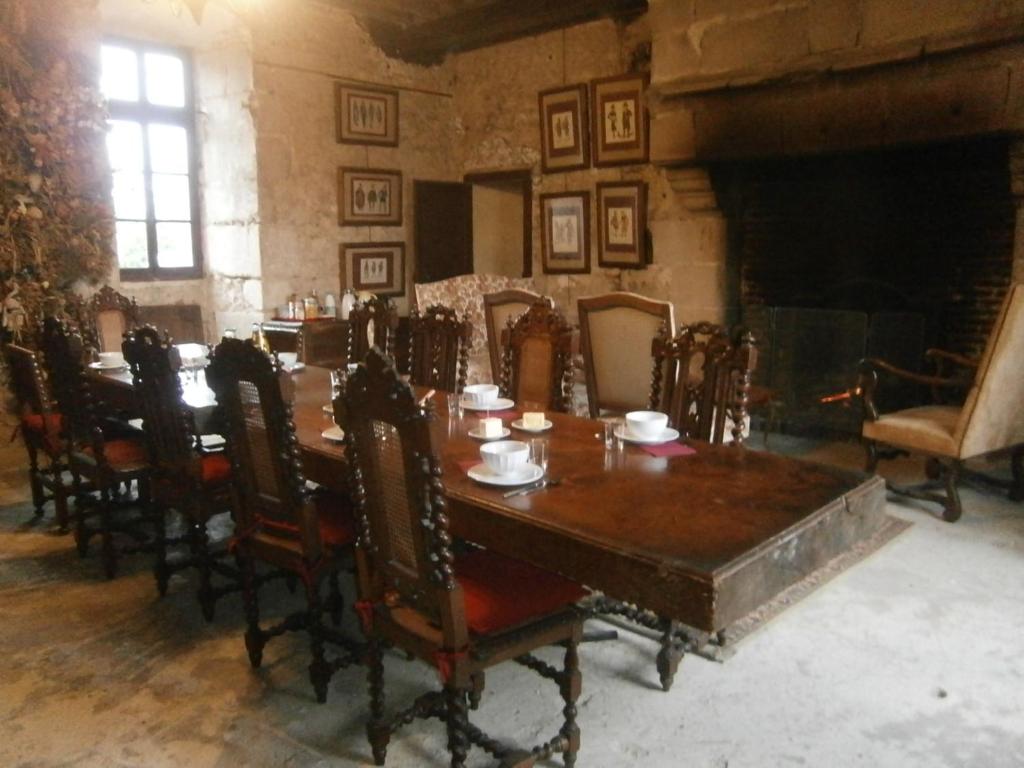 a dining room with a table and chairs and a fireplace at Chateau de Chémery in Chémery