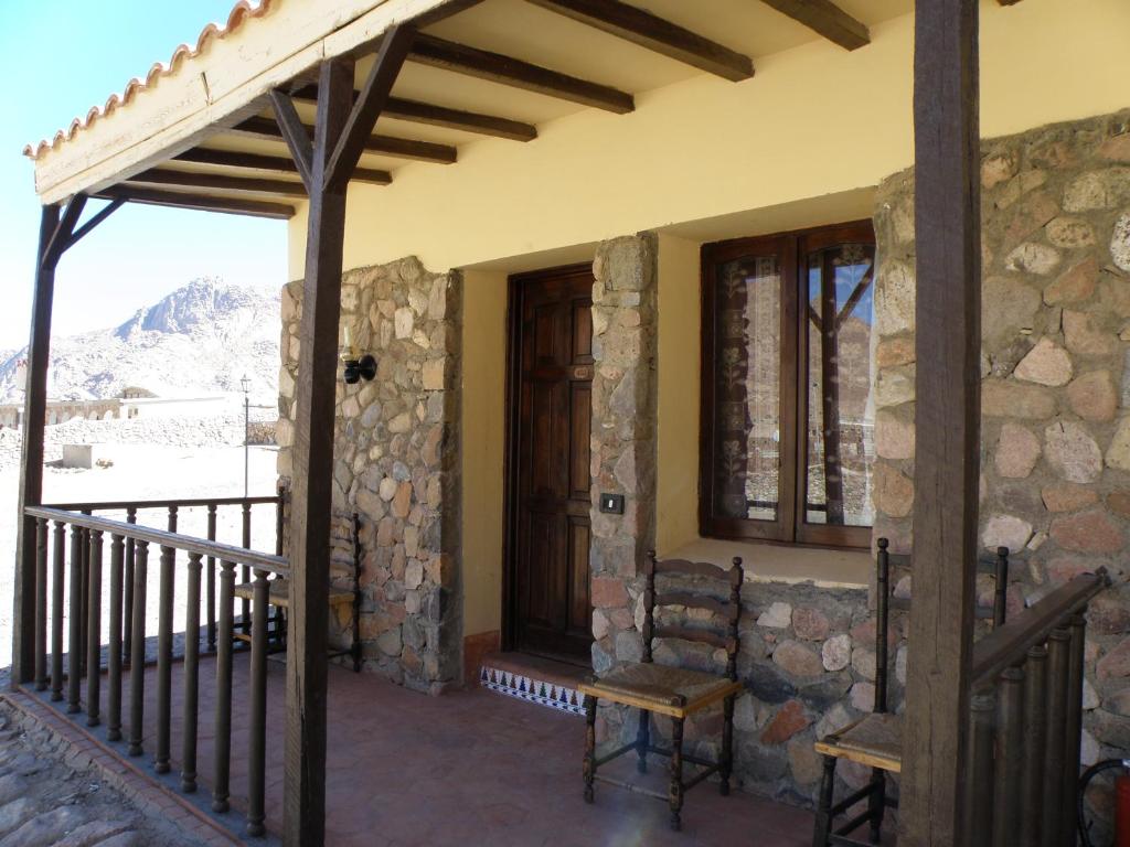 a porch of a stone house with a chair at Daniela Village St.Katherine in Saint Catherine