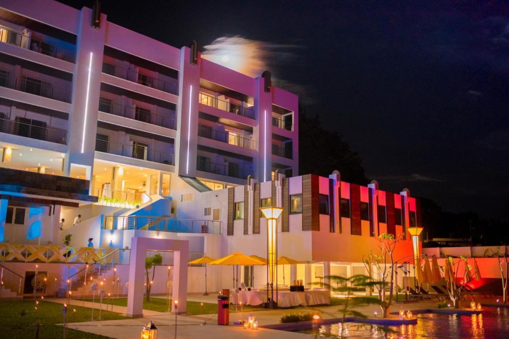 Baobab Tree Hôtel & Spa في ماهاجانجا: مبنى به أضواء ملونة أمامه في الليل