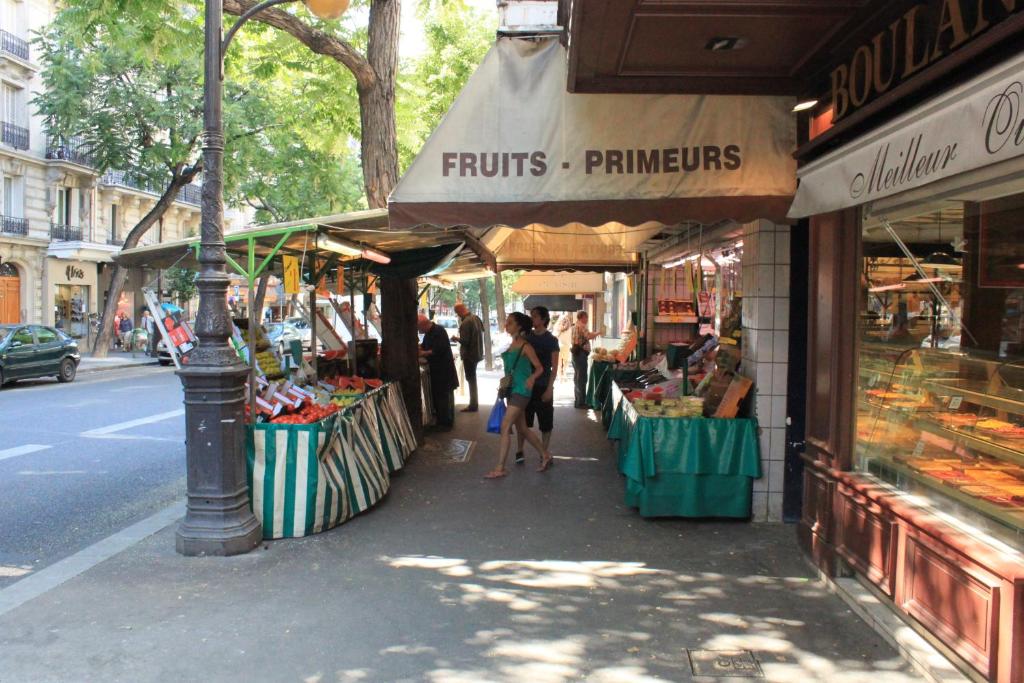 a group of people walking in front of a market at Relais Bergson in Paris