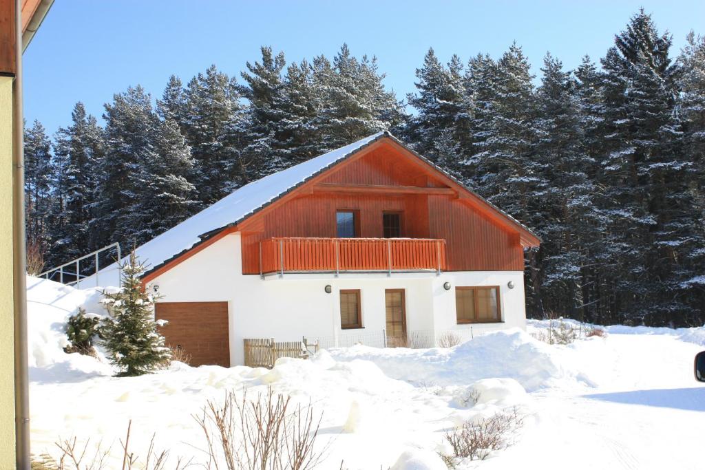 a red and white house in the snow at Villa Park Lipno-Lipno-In in Lipno nad Vltavou