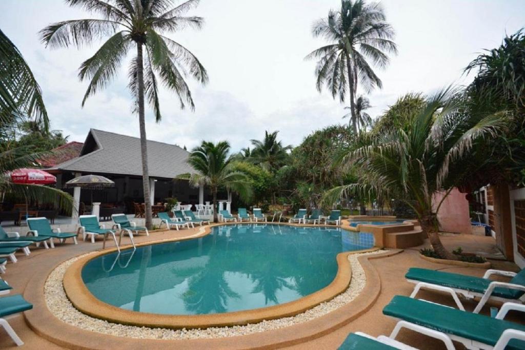 a large swimming pool with chairs and palm trees at Marina Villa in Lamai