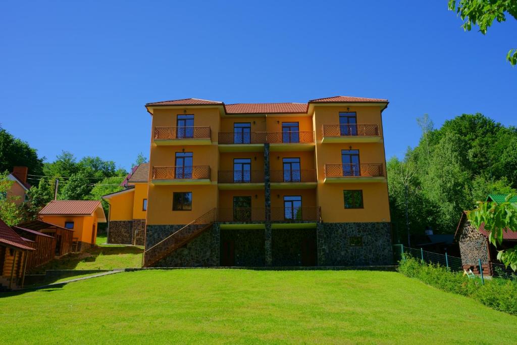ein Gebäude mit einem großen Hof davor in der Unterkunft Vovk Gasthaus in Synjak
