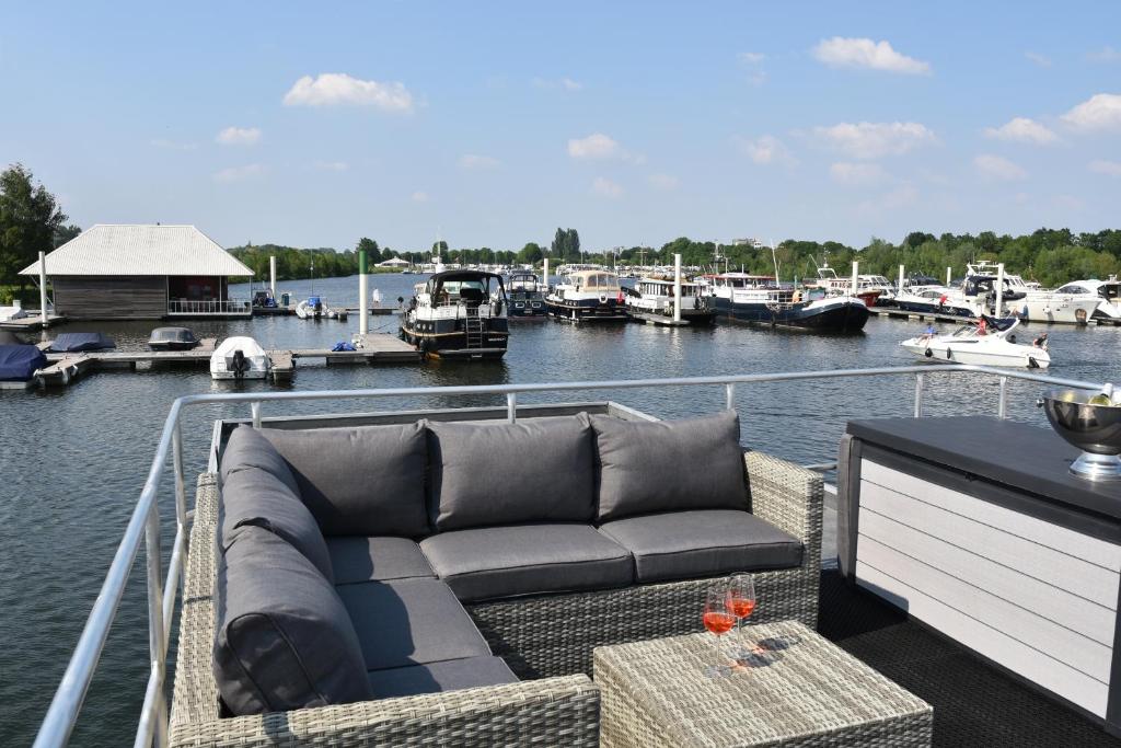 a couch sitting on the deck of a boat at Cosy floating boatlodge, "Paris" in Maastricht