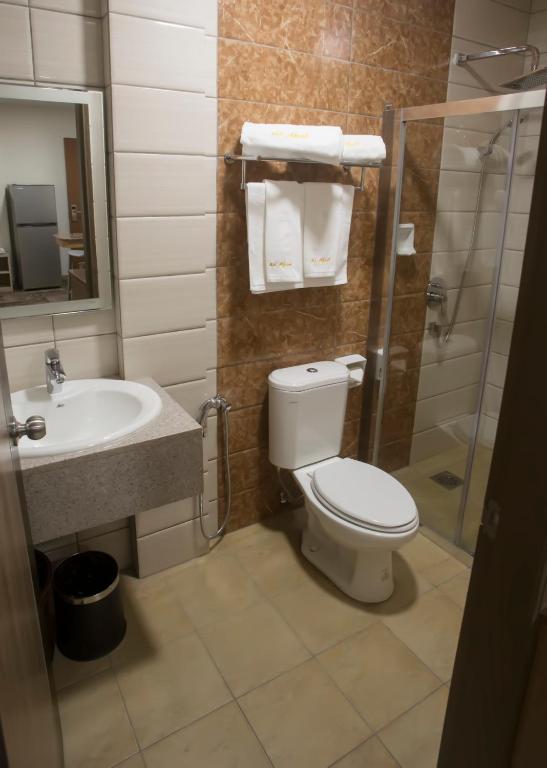 a bathroom with a toilet and a sink and a shower at Al Afiah Hotel in Bandar Seri Begawan