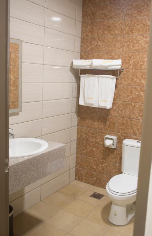 a bathroom with a toilet and a sink and a tub at Al Afiah Hotel in Bandar Seri Begawan