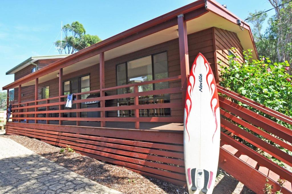 a surfboard sitting on the side of a house at WAVELENGTH - WIFI & PET FRIENDLY (OUTSIDE ONLY) in Inverloch