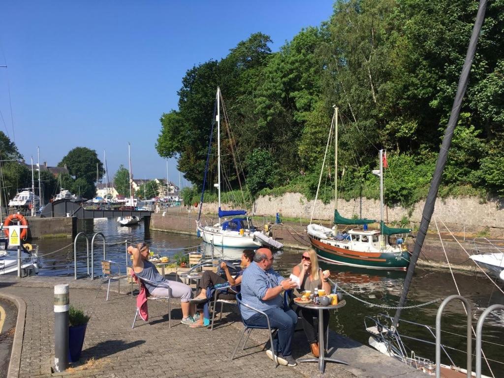 a group of people sitting at a table with boats in the water at Stunning House in Felinheli Marina in Y Felinheli