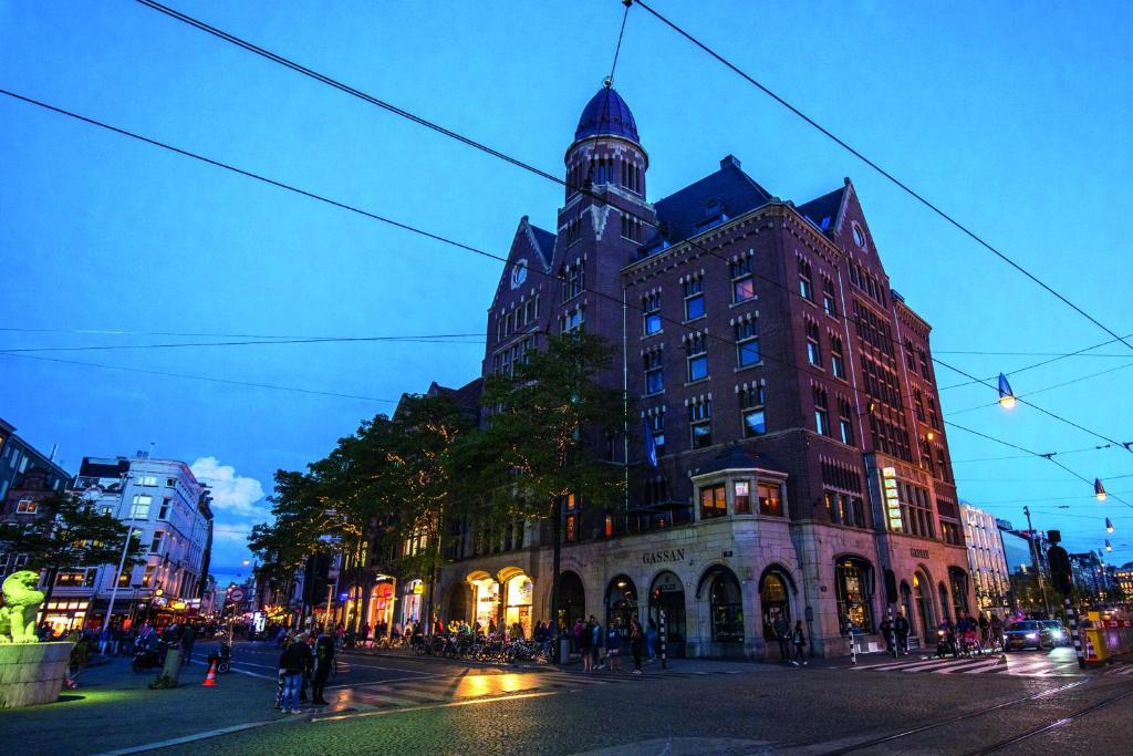 un grand bâtiment situé dans une rue de la ville la nuit dans l'établissement Hotel TwentySeven - Small Luxury Hotels of the World, à Amsterdam