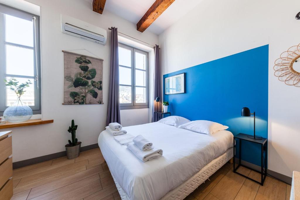 マルセイユにあるJADE - LES COCONSのベッドルーム1室(大型ベッド1台、青いヘッドボード付)