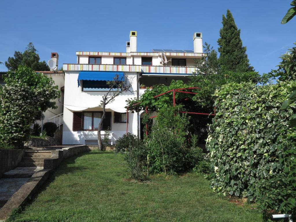 een wit huis met een tuin ervoor bij Apartments Potočki in Medulin