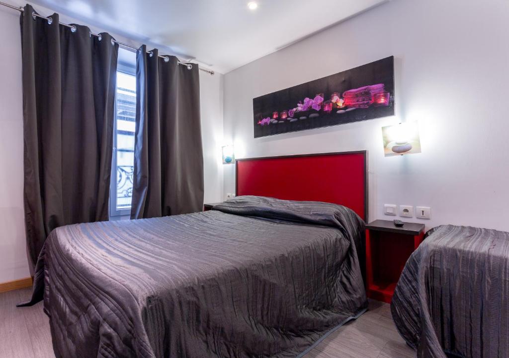 パリにあるVictory Hotel Galouのベッドルーム1室(ベッド1台、赤いヘッドボード付)