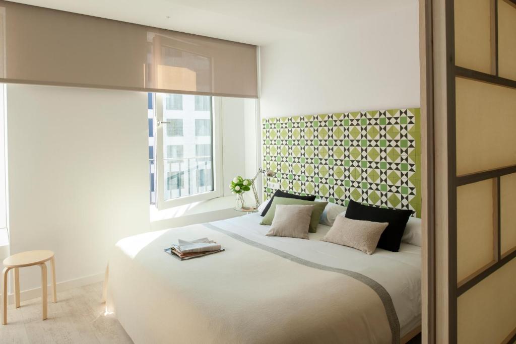 a bedroom with a large white bed and a window at Eric Vökel Boutique Apartments - Hamburg Suites in Hamburg