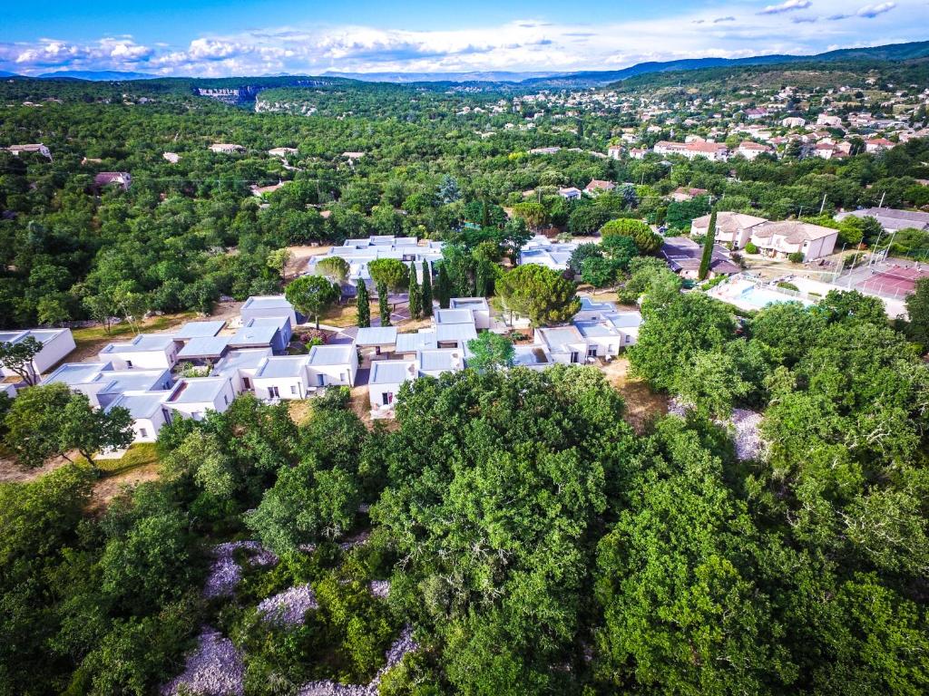an overhead view of a large white house in the woods at Village Vacances passion La Buissière in Labeaume