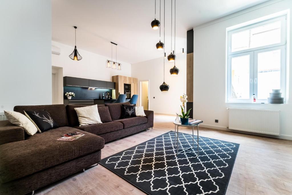 ein Wohnzimmer mit einem Sofa und einem Tisch in der Unterkunft Highrise Oasis Apartment in Budapest