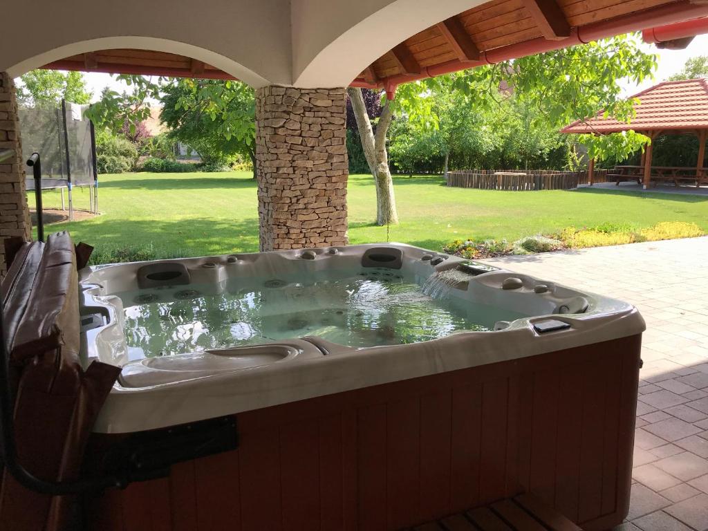 a jacuzzi tub sitting under a gazebo at Villa Holiday in Poroszló