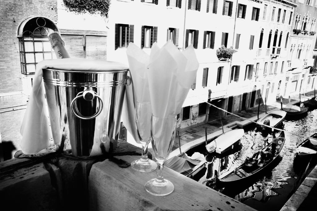 two wine glasses sitting next to a trash can at Hotel Pausania in Venice