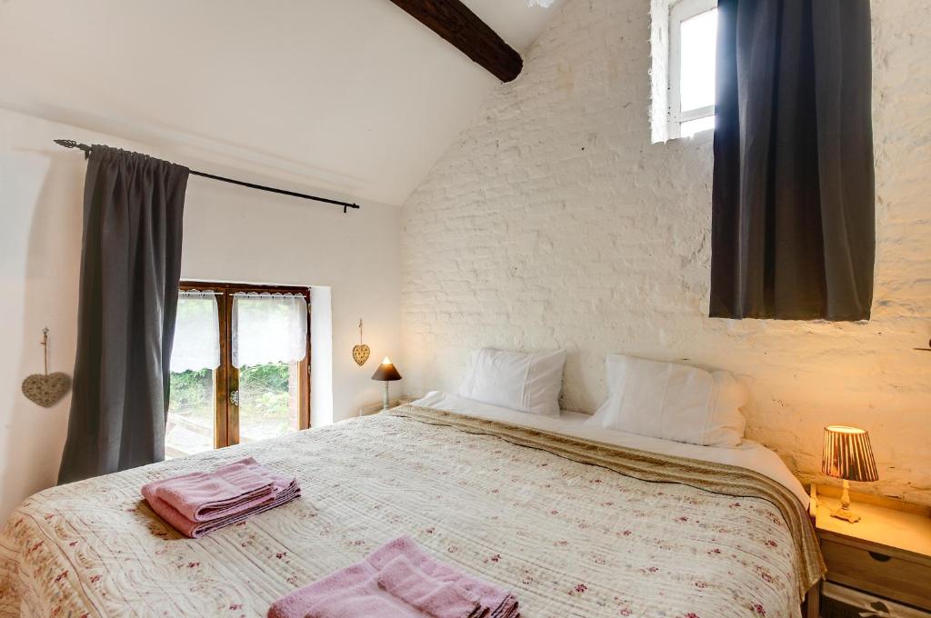 sypialnia z dużym łóżkiem i oknem w obiekcie Gîte Bucolique- Belle Epoque w mieście Durbuy