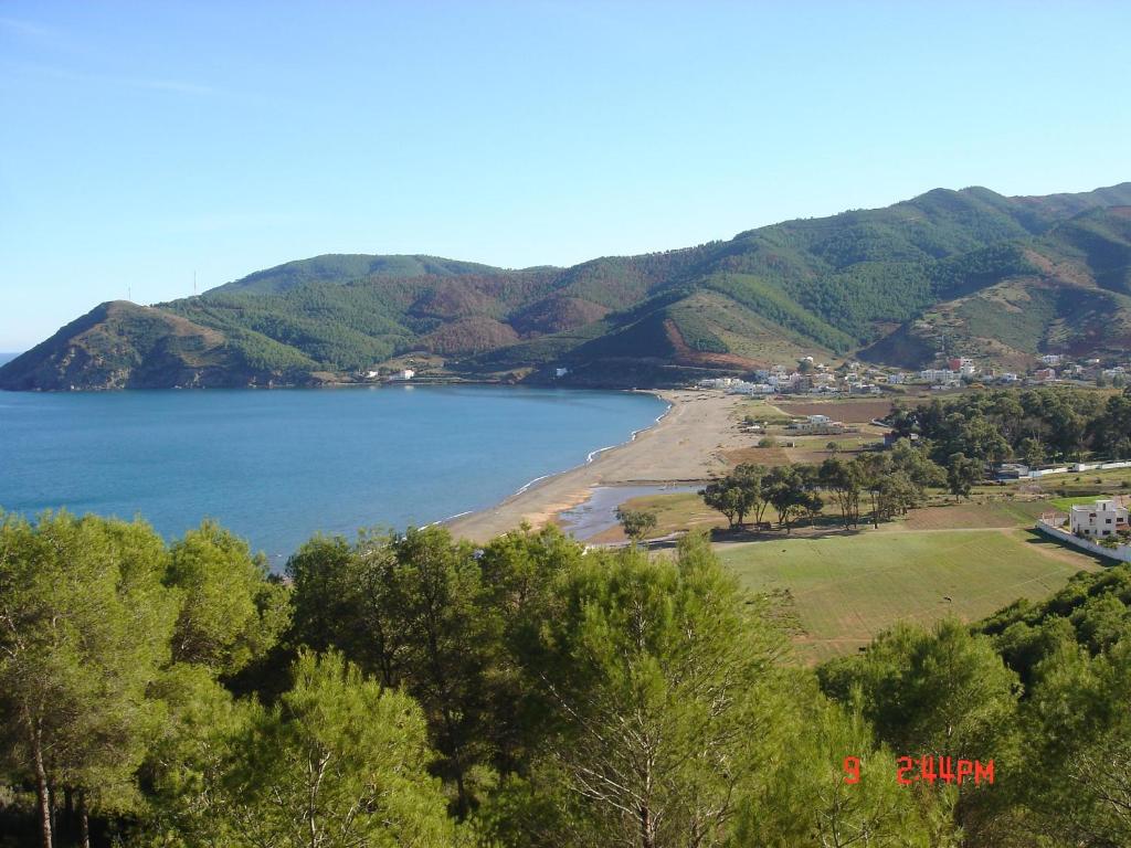 a view of a beach with trees and mountains at Amsabeach in Chozas