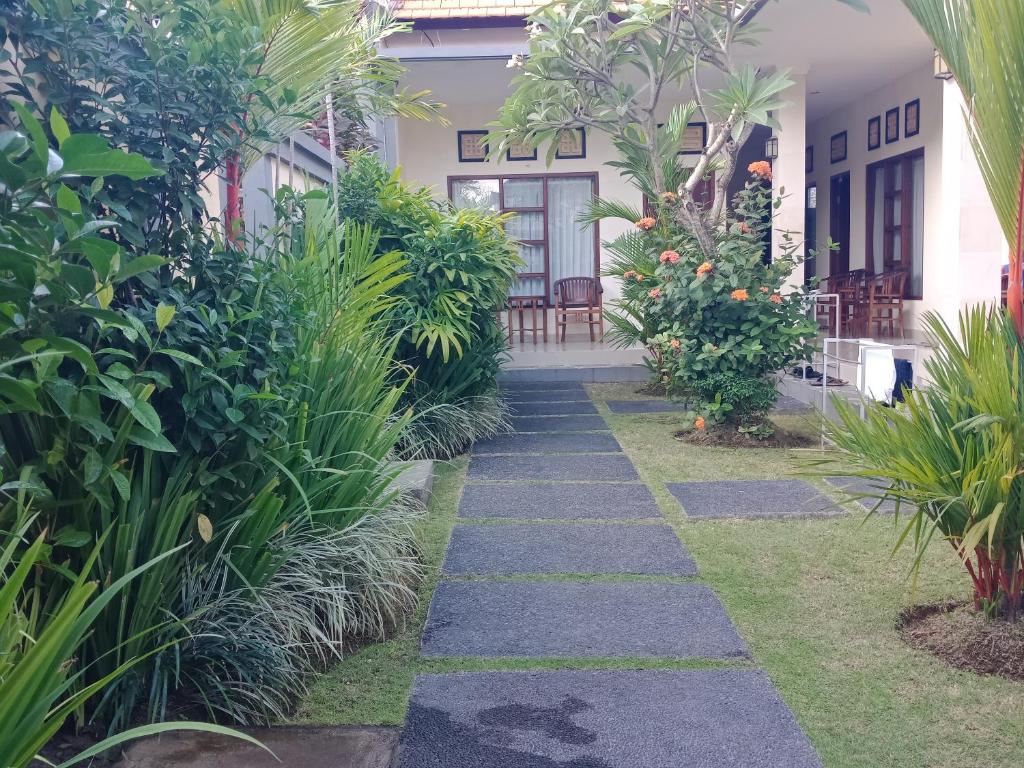 a walkway in front of a house with plants at Purnama Guesthouse in Canggu