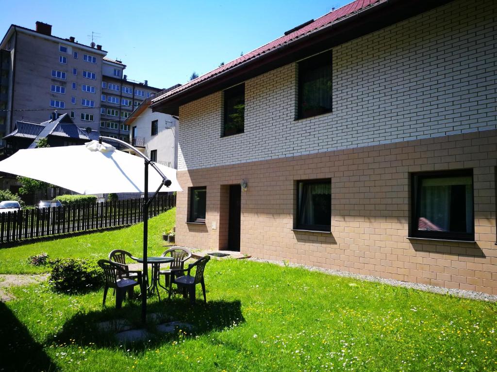 a table and chairs in a yard next to a building at Apartament u Michała in Krynica Zdrój