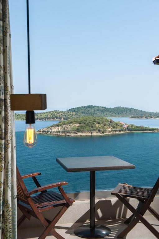 a table and chairs on a balcony with a view of the water at Thalassokipos in Vourvourou
