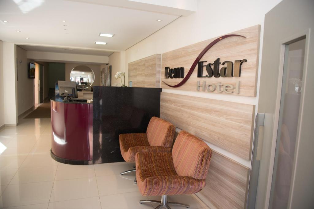 a hotel lobby with two chairs in front of a counter at Hotel Bem Estar in Ibitinga