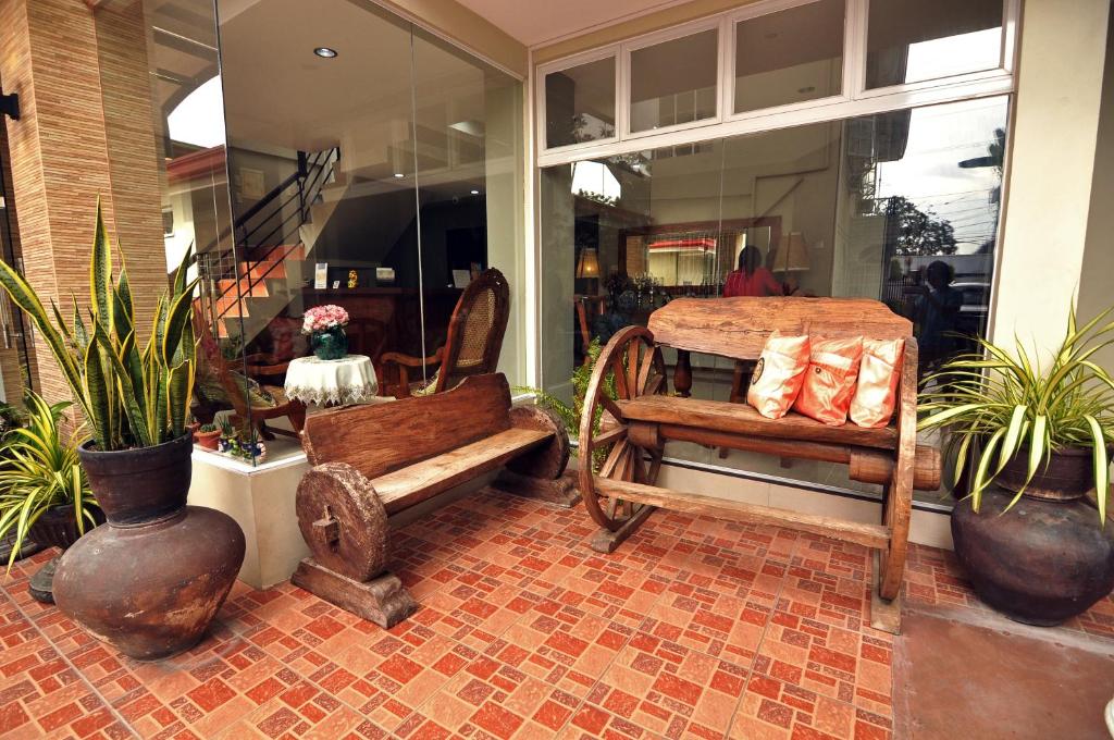 a store window with a bench and potted plants at Harbour Gardens Tourist Inn in Tagbilaran City