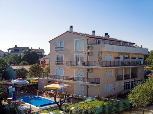 a large building with a swimming pool and a hotel at Pansion Sport in Štinjan