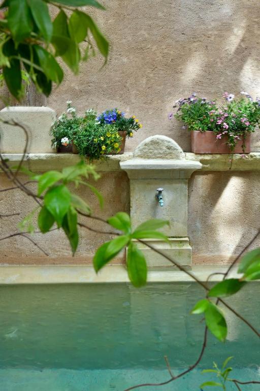 a bird bath with potted plants on a wall at Un Mas en Ville in Marseille